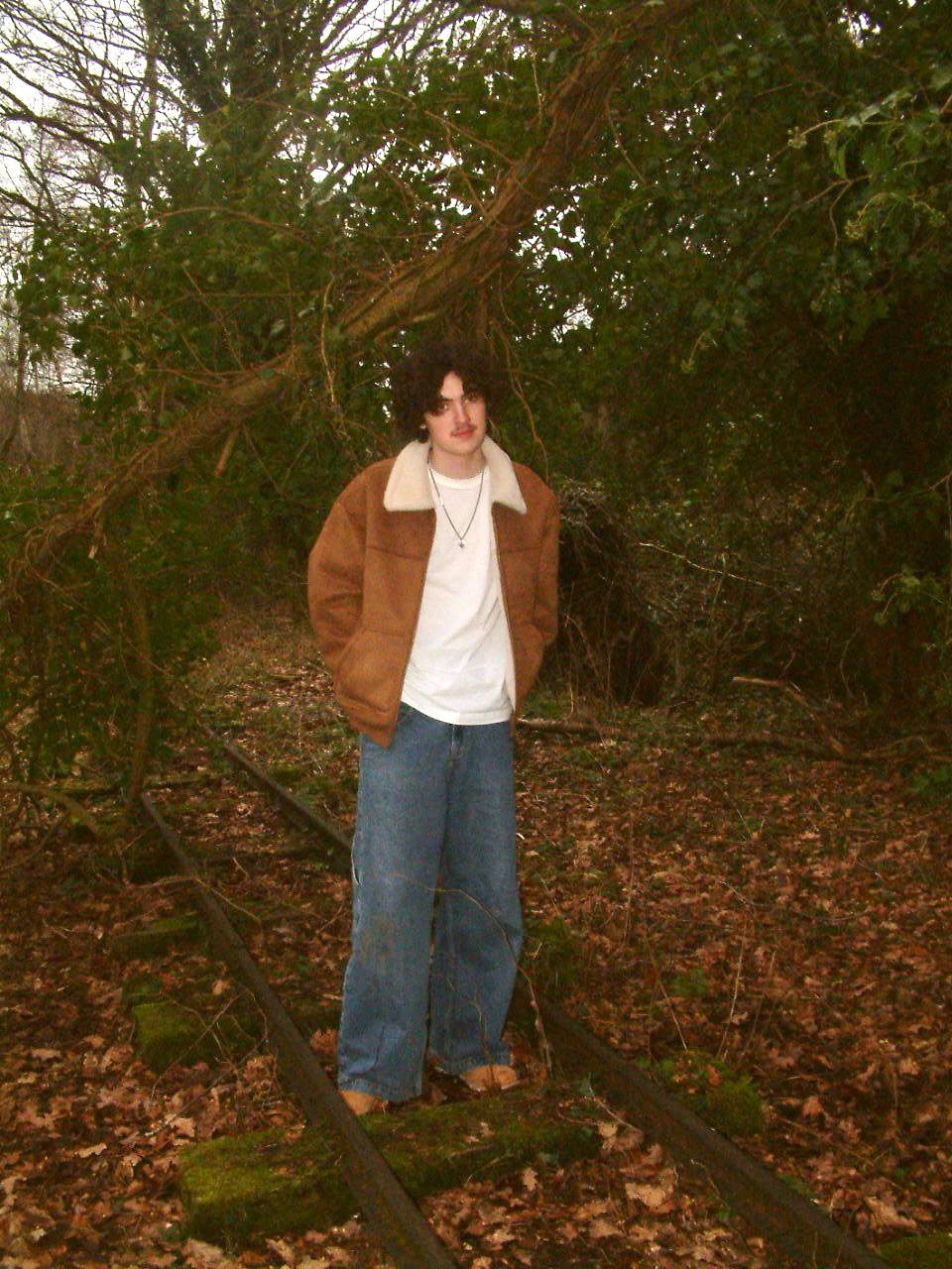 Harry Huxley standing on overgrown railway tracks